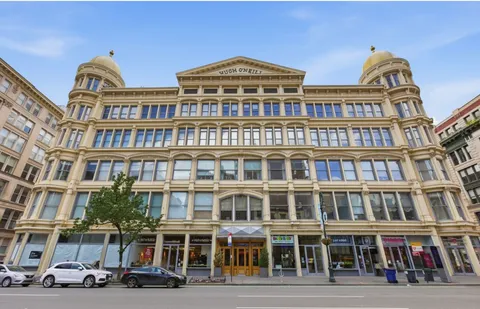 a front view of a building with lot of cars parked