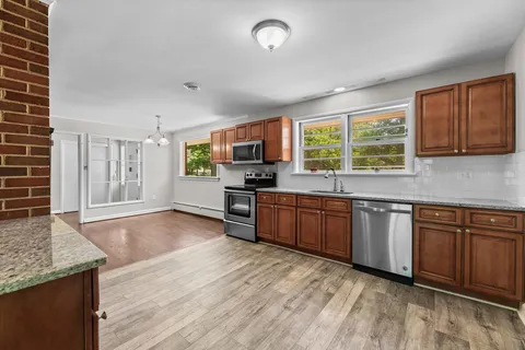 a kitchen with stainless steel appliances granite countertop a stove sink and cabinets