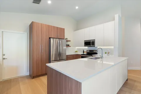 an open kitchen with a sink and stove top oven