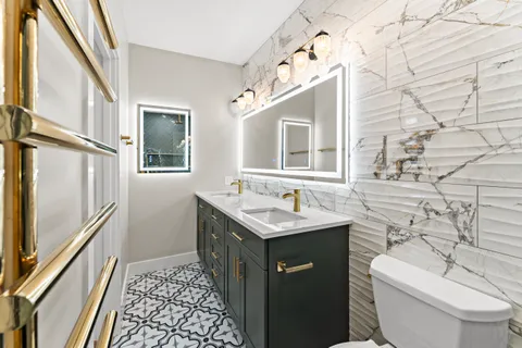 a bathroom with a granite countertop sink toilet and mirror