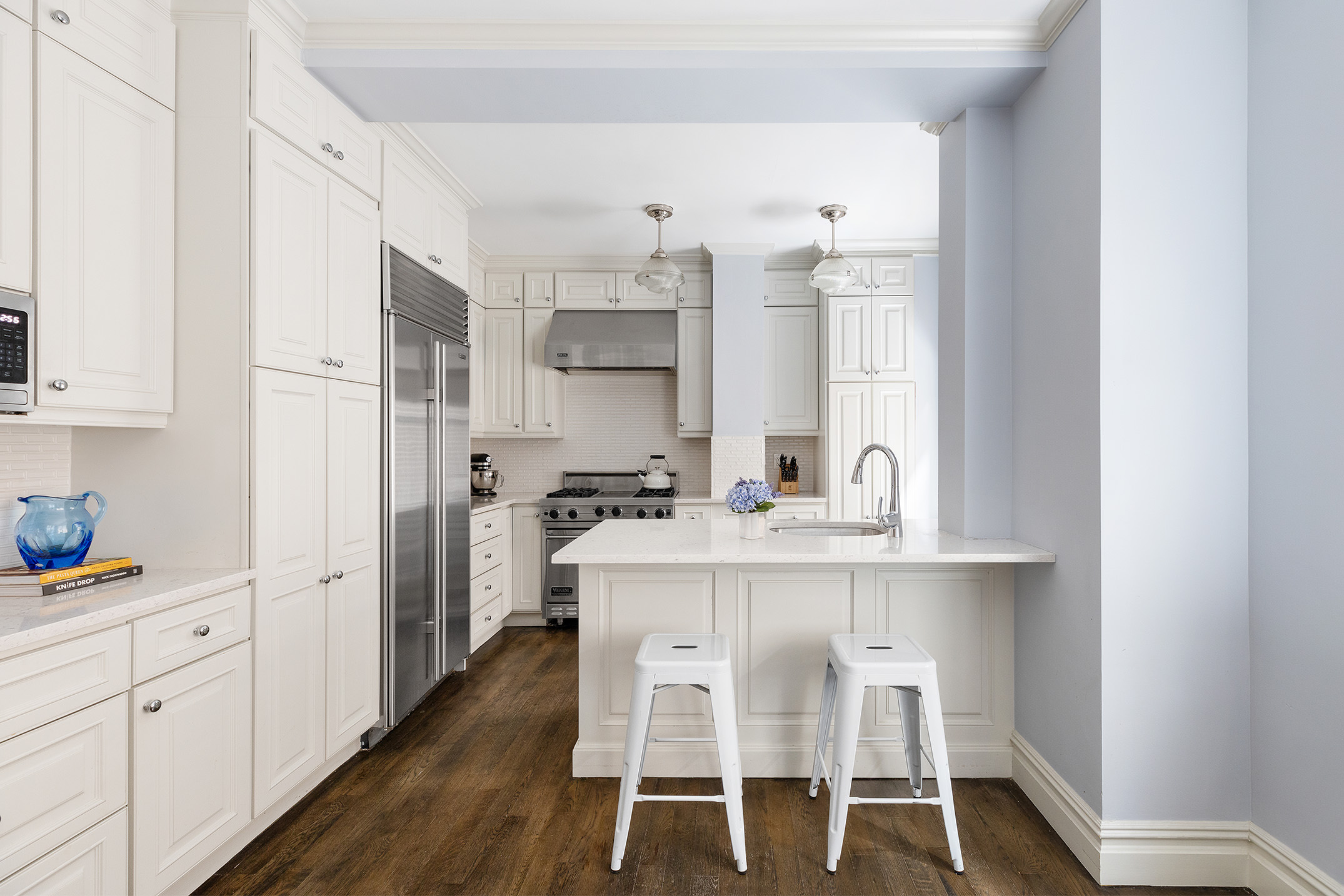 174 West 76th Street, Unit 4GH Manhattan, NY 10023 - Photo 5 of 16 a kitchen with white cabinets and chairs