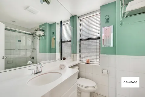 a bathroom with a sink a toilet and shower