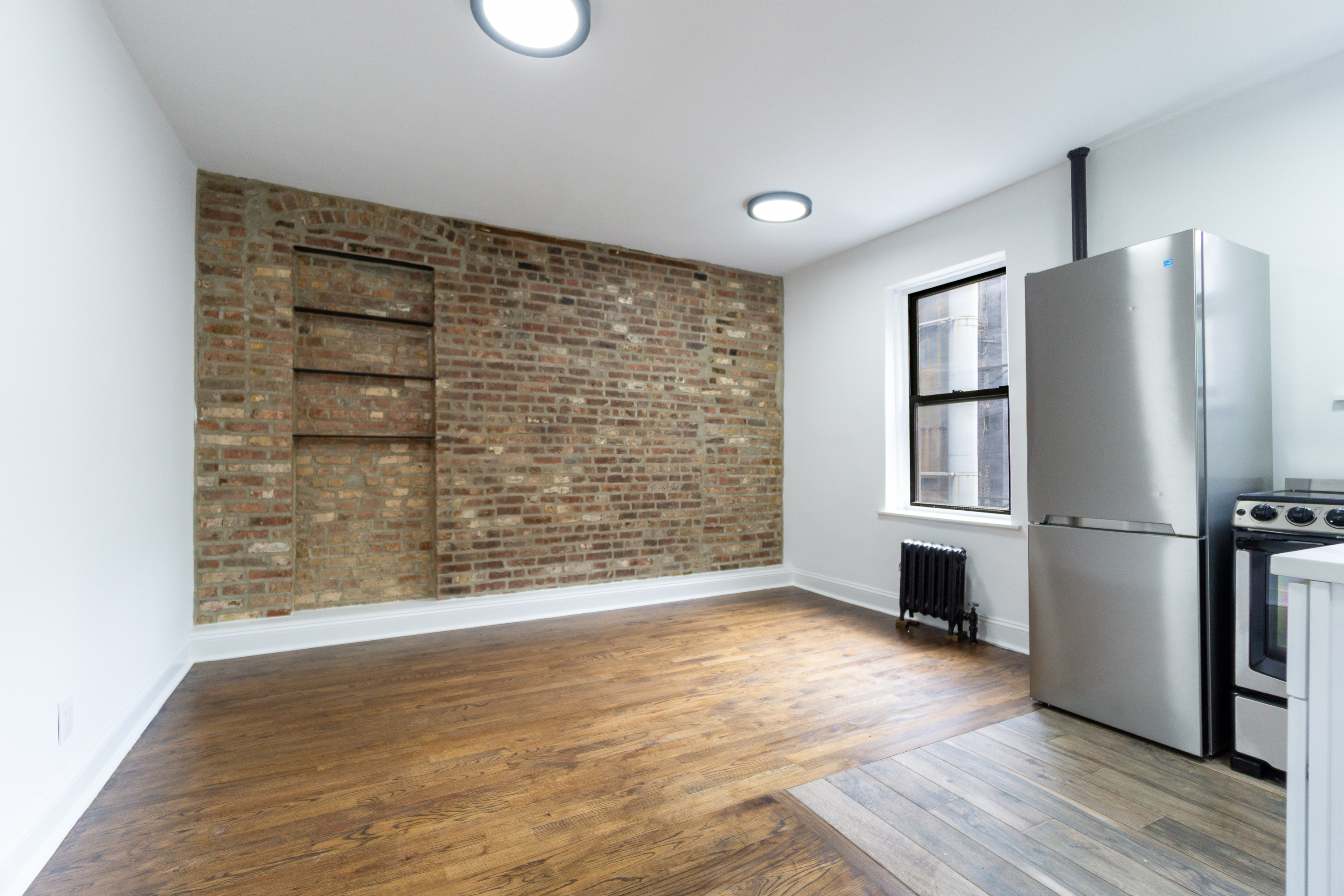 342 East 6th Street, Unit 3 Manhattan, NY 10003 - Photo 2 of 13 a view of an empty room with a kitchen and a window