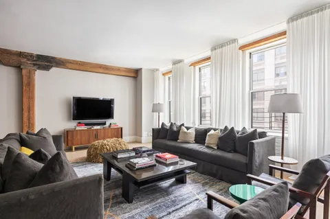 a living room with furniture a flat screen tv and a window