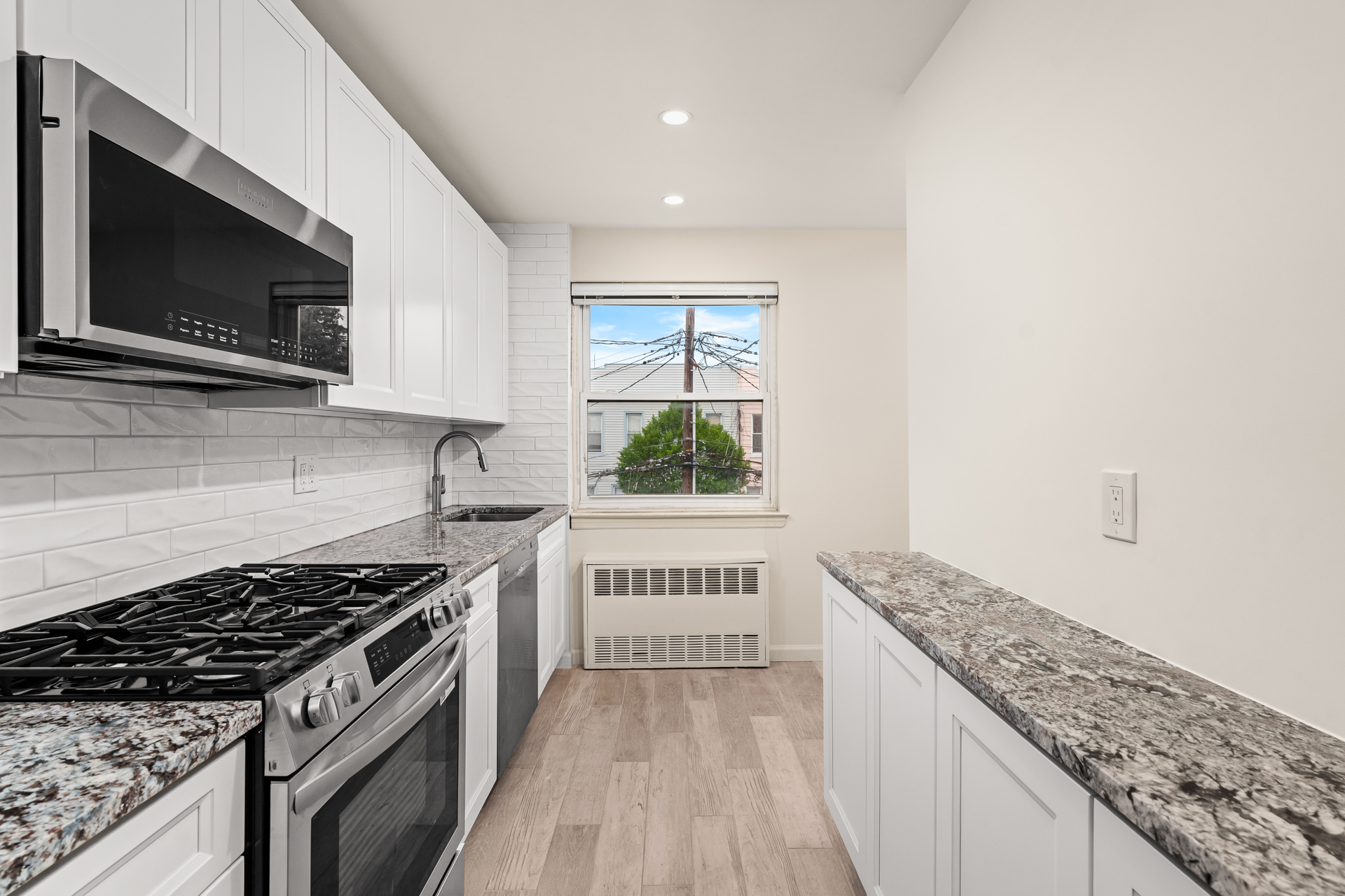412 Fairview Avenue, Unit 2 Queens, NY 11385 - Photo 3 of 8 a kitchen with stainless steel appliances granite countertop a stove and a microwave