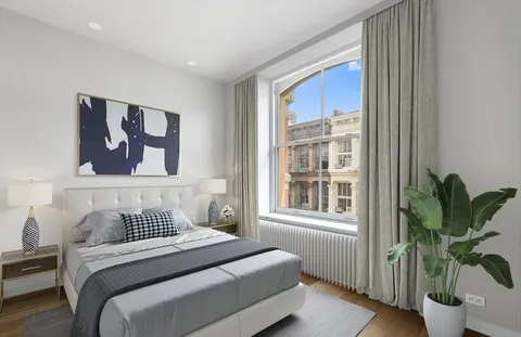 a bedroom with a large bed and a potted plant