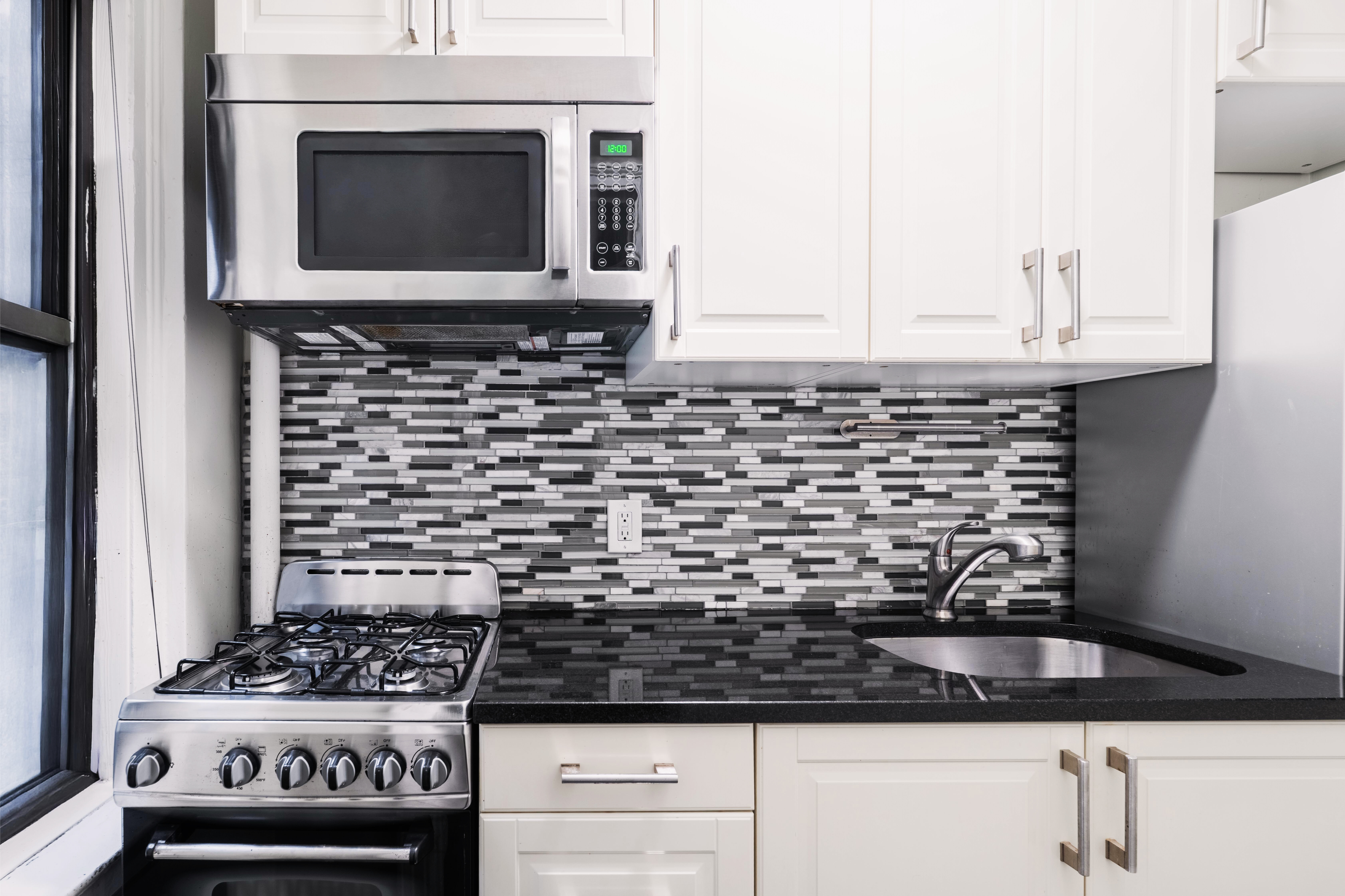 321 East 54th Street, Unit 3D Manhattan, NY 10022 - Photo 3 of 7 a kitchen with a stove and a microwave