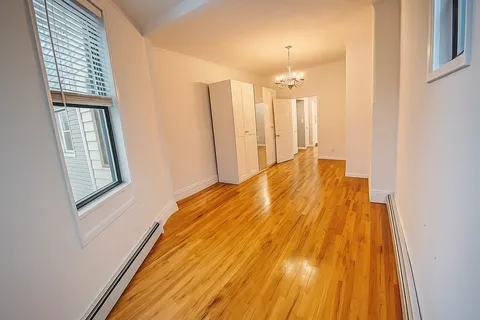 a view of a room with wooden floor and windows