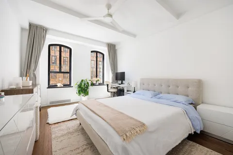 a bedroom with a large bed and windows