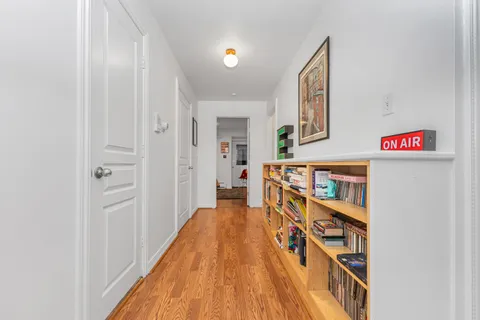 a view of a hallway with wooden floor and staircase