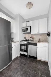 a kitchen with a stove top oven and cabinets
