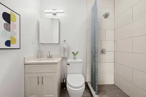 a bathroom with a toilet a sink and mirror