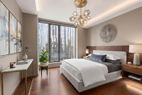 a bedroom with a large bed and a chandelier