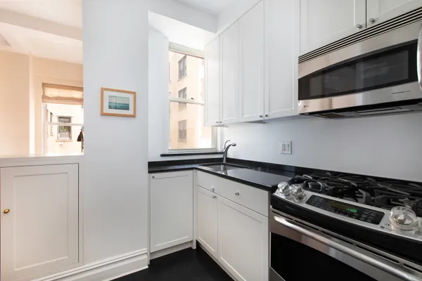 a kitchen with stainless steel appliances white cabinets and a stove top oven