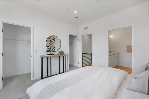 a bedroom with a large bed and a chandelier