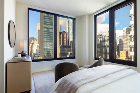 a bedroom with a large bed and a large window