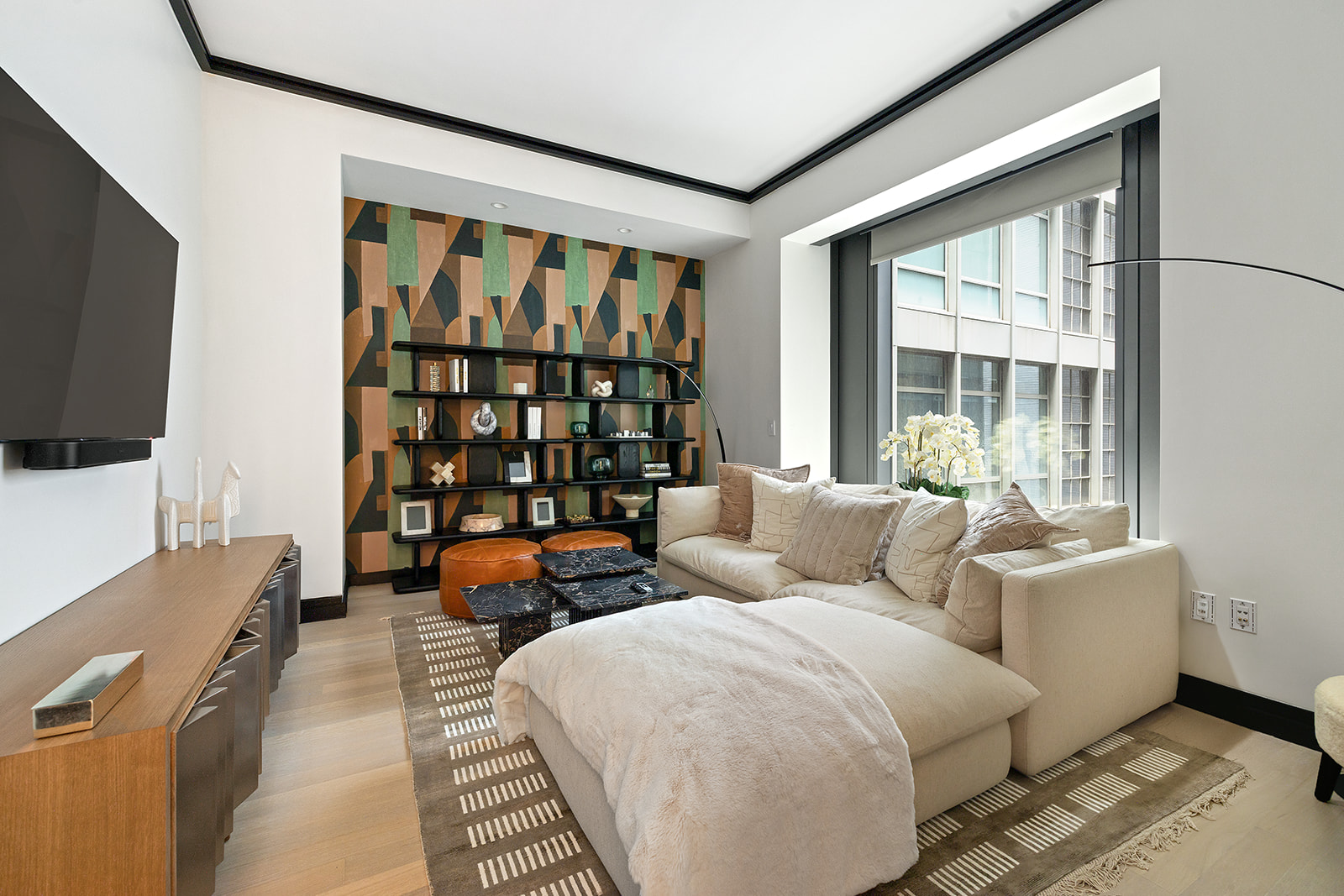 53 West 53rd Street, Unit 28D Manhattan, NY 10019 - Photo 6 of 22 a living room with furniture and a flat screen tv