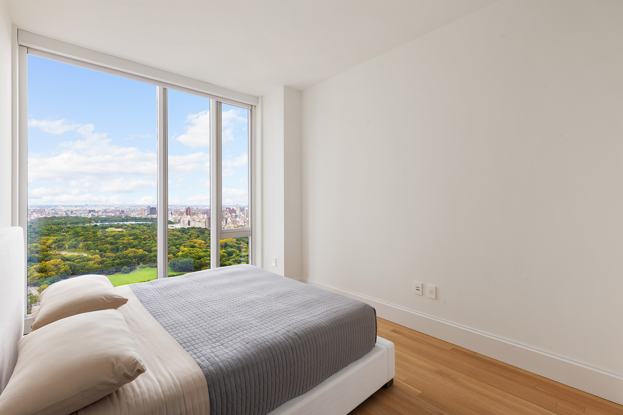 217 West 57th Street, Unit 57N Manhattan, NY 10019 - Photo 4 of 10 a bed sitting in a bedroom next to a window