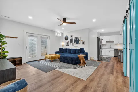 a kitchen with stainless steel appliances granite countertop a stove a refrigerator a sink dishwasher a dining table and chairs with wooden floor