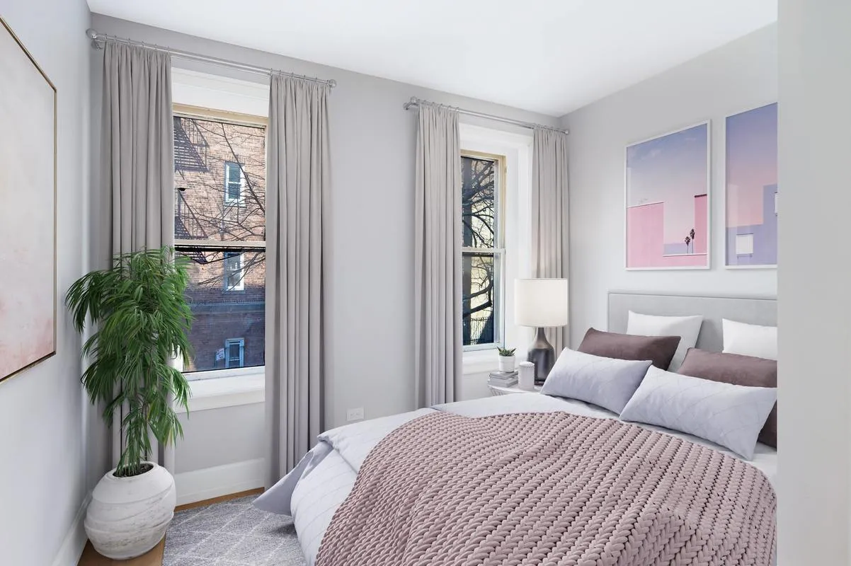 a bedroom with a large bed and a potted plant