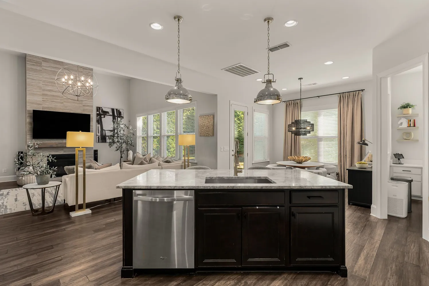 a kitchen with stainless steel appliances kitchen island granite countertop a table chairs and a refrigerator