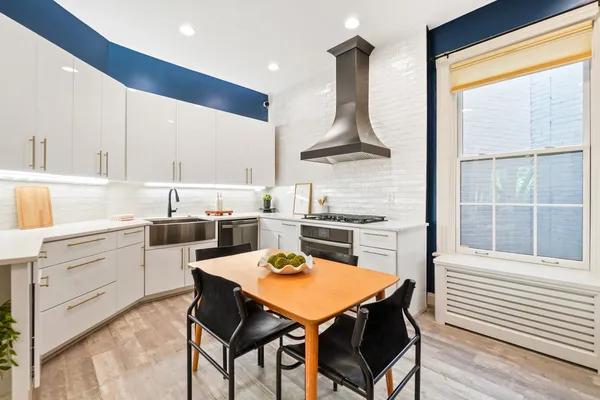 a kitchen with a table chairs sink and cabinets