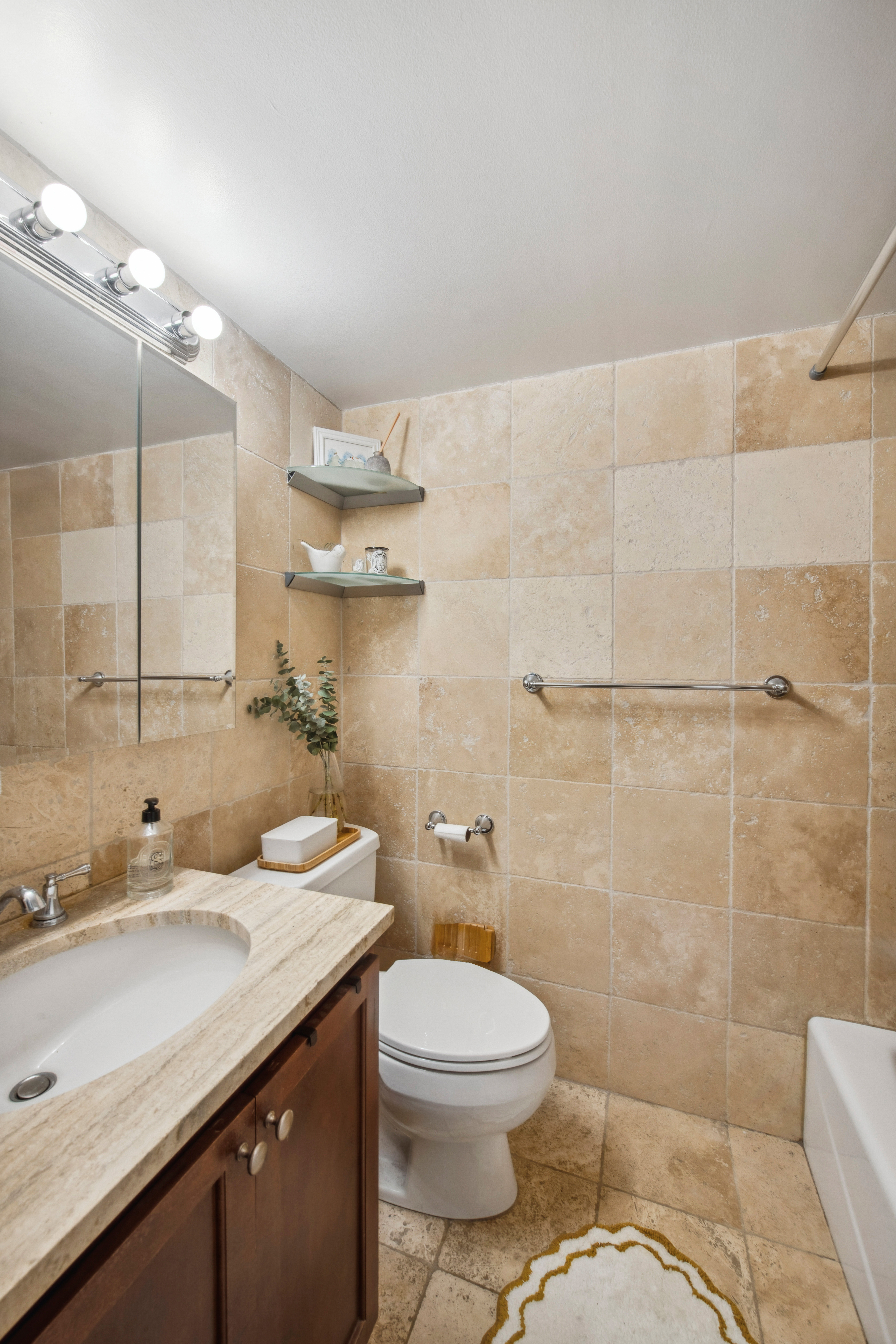 350 East 62nd Street, Unit 3J Manhattan, NY 10065 - Photo 7 of 9 a bathroom with a granite countertop sink a toilet and shower