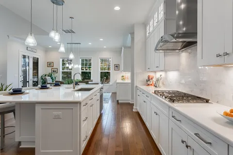 a kitchen with kitchen island stainless steel appliances a sink stove and cabinets