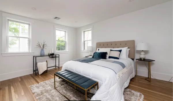a bedroom with a bed table and a window