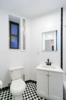 a bathroom with a toilet a sink and mirror