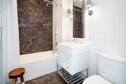 a bathroom with a sink a toilet a vanity and mirror