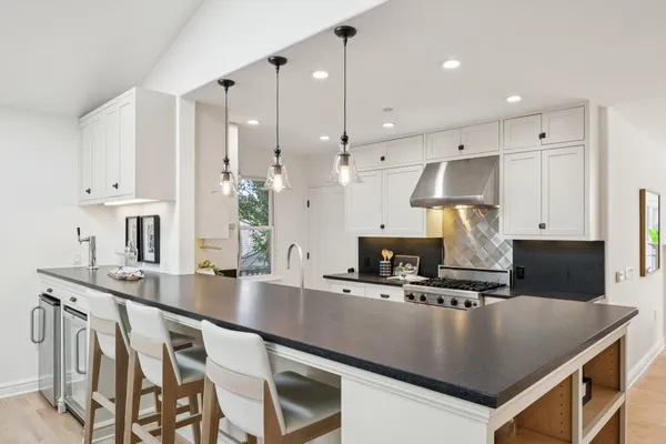 a kitchen with stainless steel appliances granite countertop a sink a stove and a refrigerator