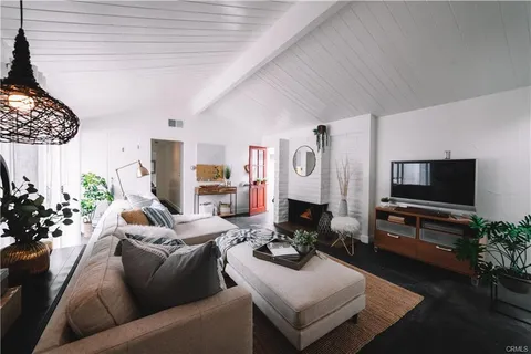 a living room with furniture a flat screen tv and a potted plant