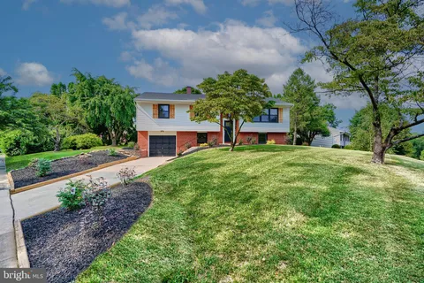 a view of a house with a small yard and a large tree