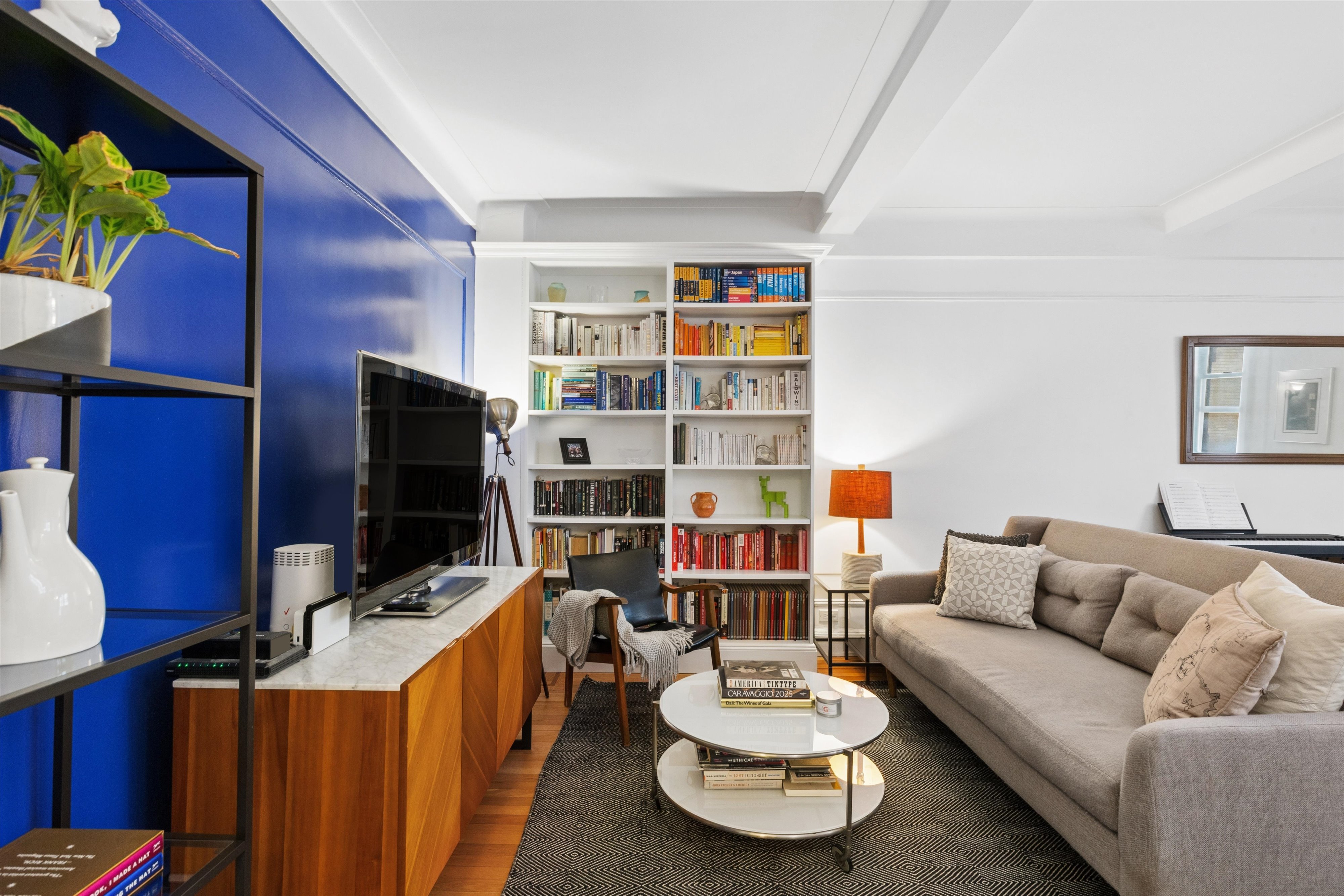 41 West 72nd Street, Unit 15E Manhattan, NY 10023 - Photo 2 of 12 a living room with furniture and a flat screen tv