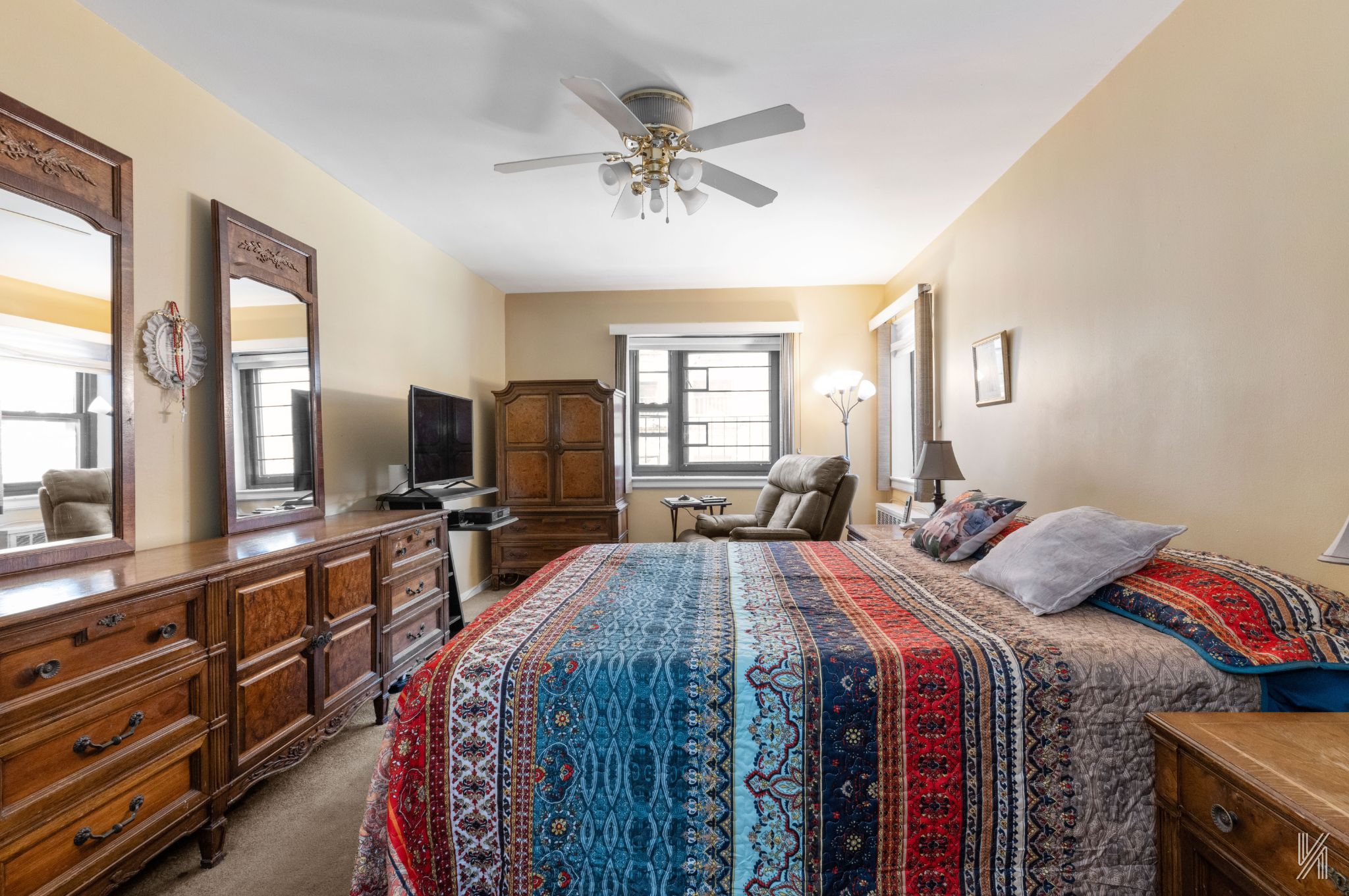 34-10 94th Street, Unit 3D Queens, NY 11372 - Photo 11 of 17 a bed room with a bed a couch and a chandelier