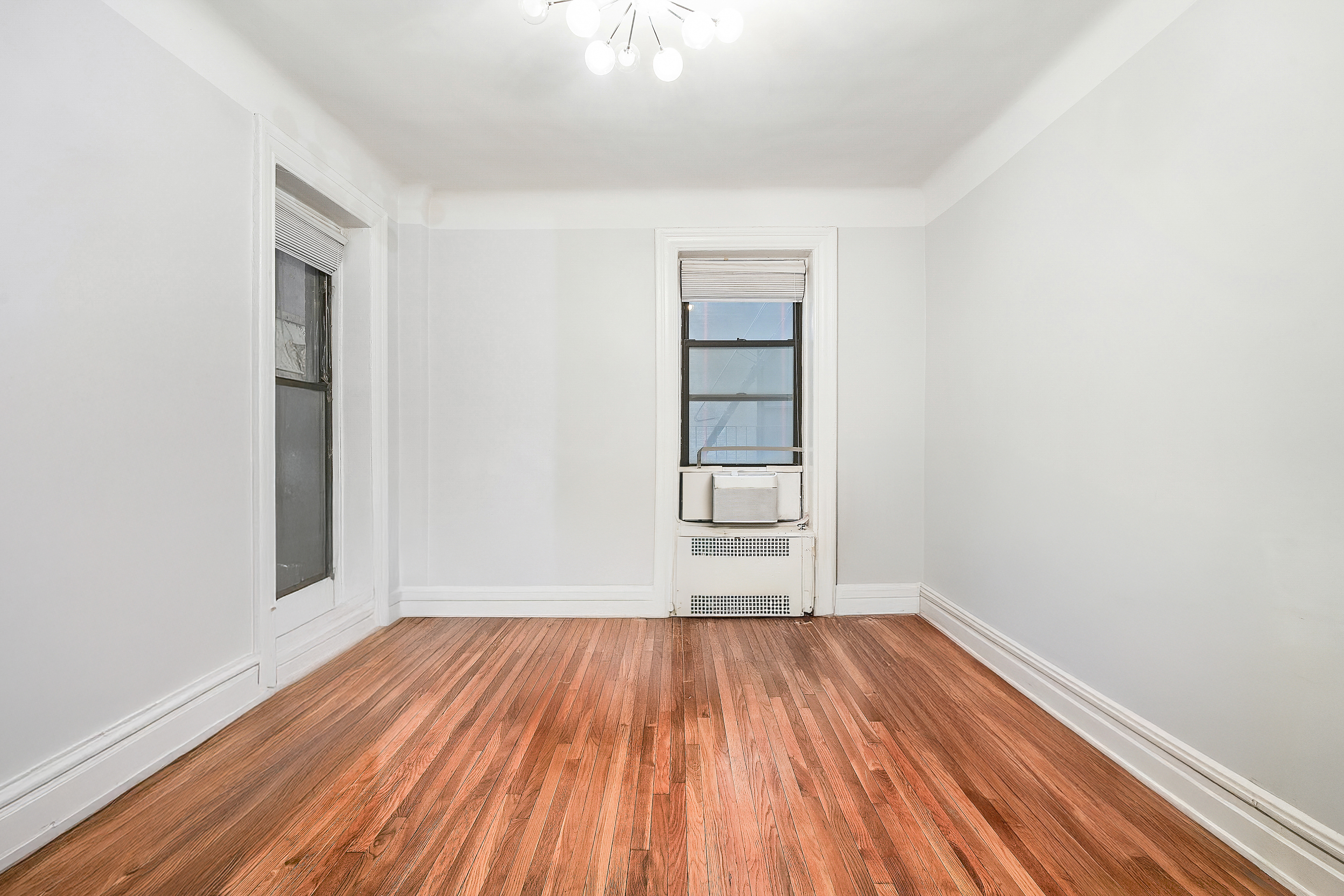 205 West 54th Street, Unit 3A Manhattan, NY 10019 - Photo 4 of 14 a view of a room with wooden floor and window