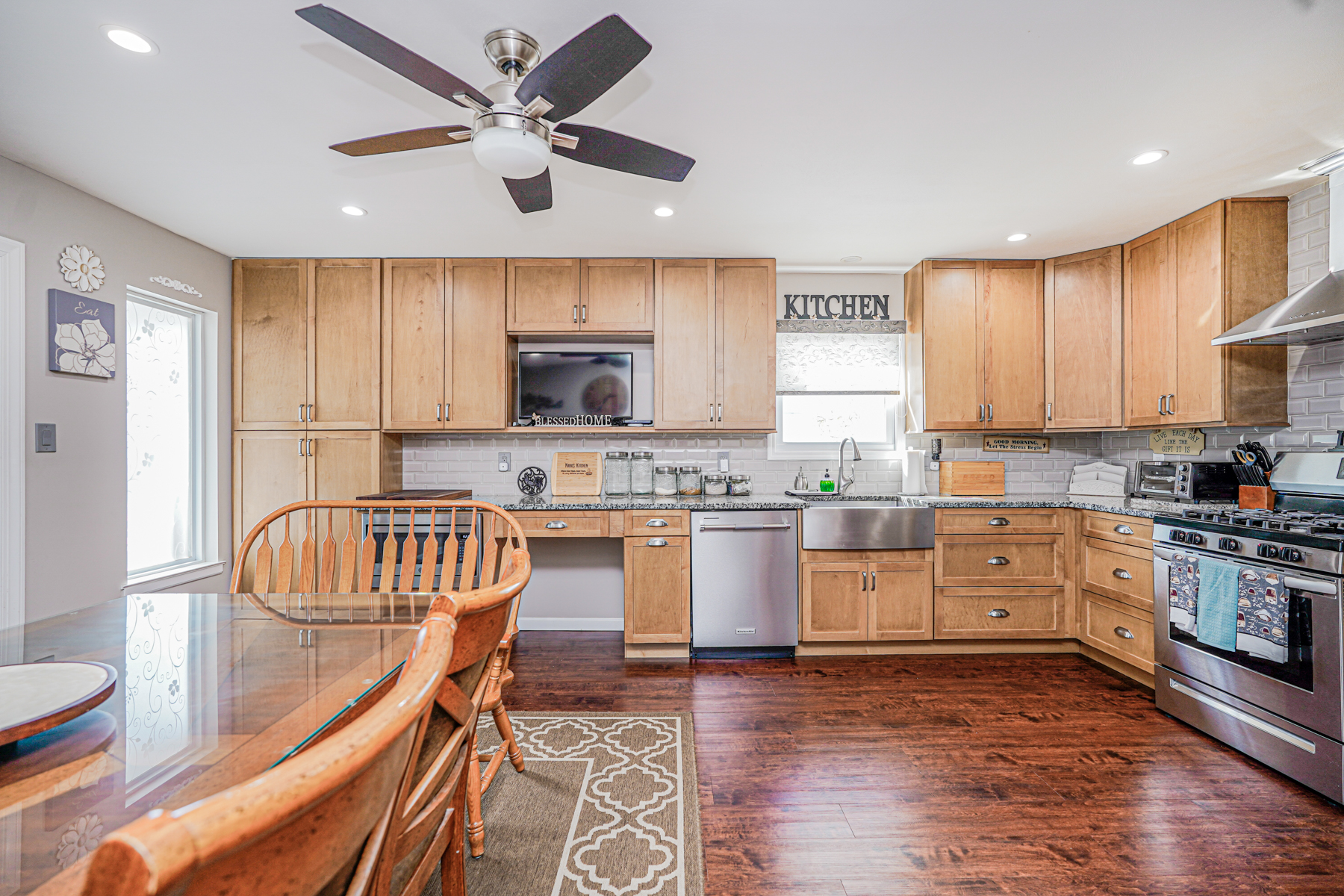 287 Greaves Avenue Staten Island, NY 10308 - Photo 12 of 35 a kitchen with kitchen island granite countertop wooden floors white cabinets and stainless steel appliances