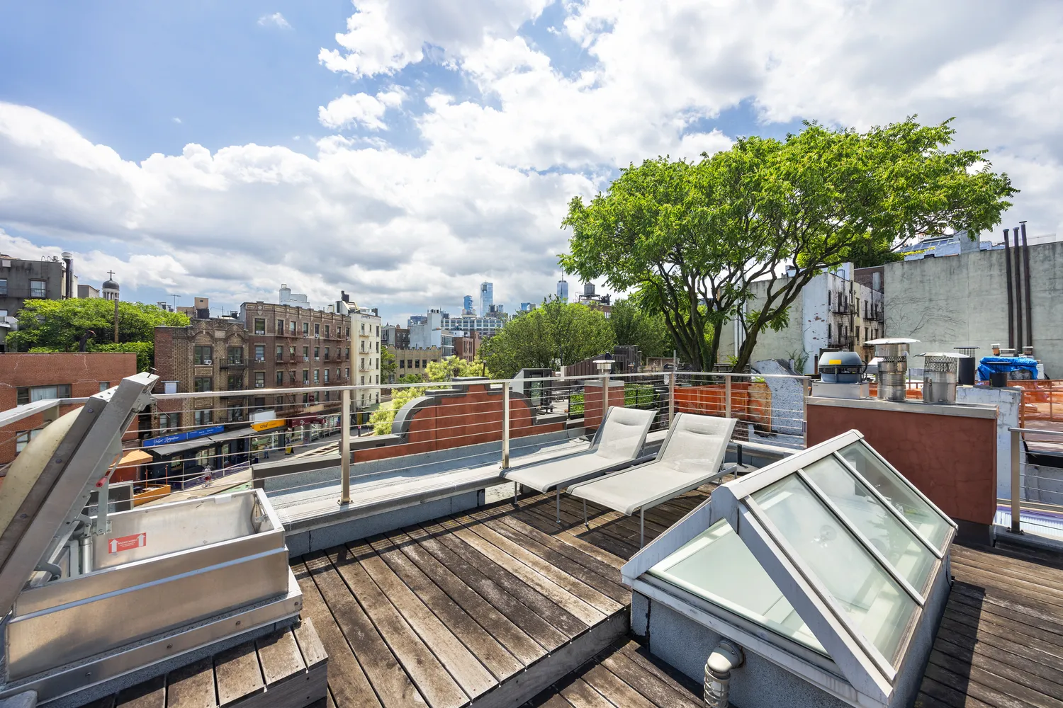 a view of a roof deck with couches and wooden floor