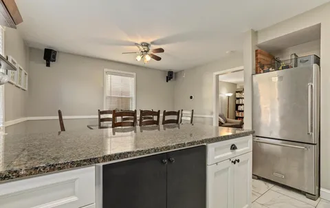 a kitchen with stainless steel appliances granite countertop a sink a refrigerator and a granite counter tops