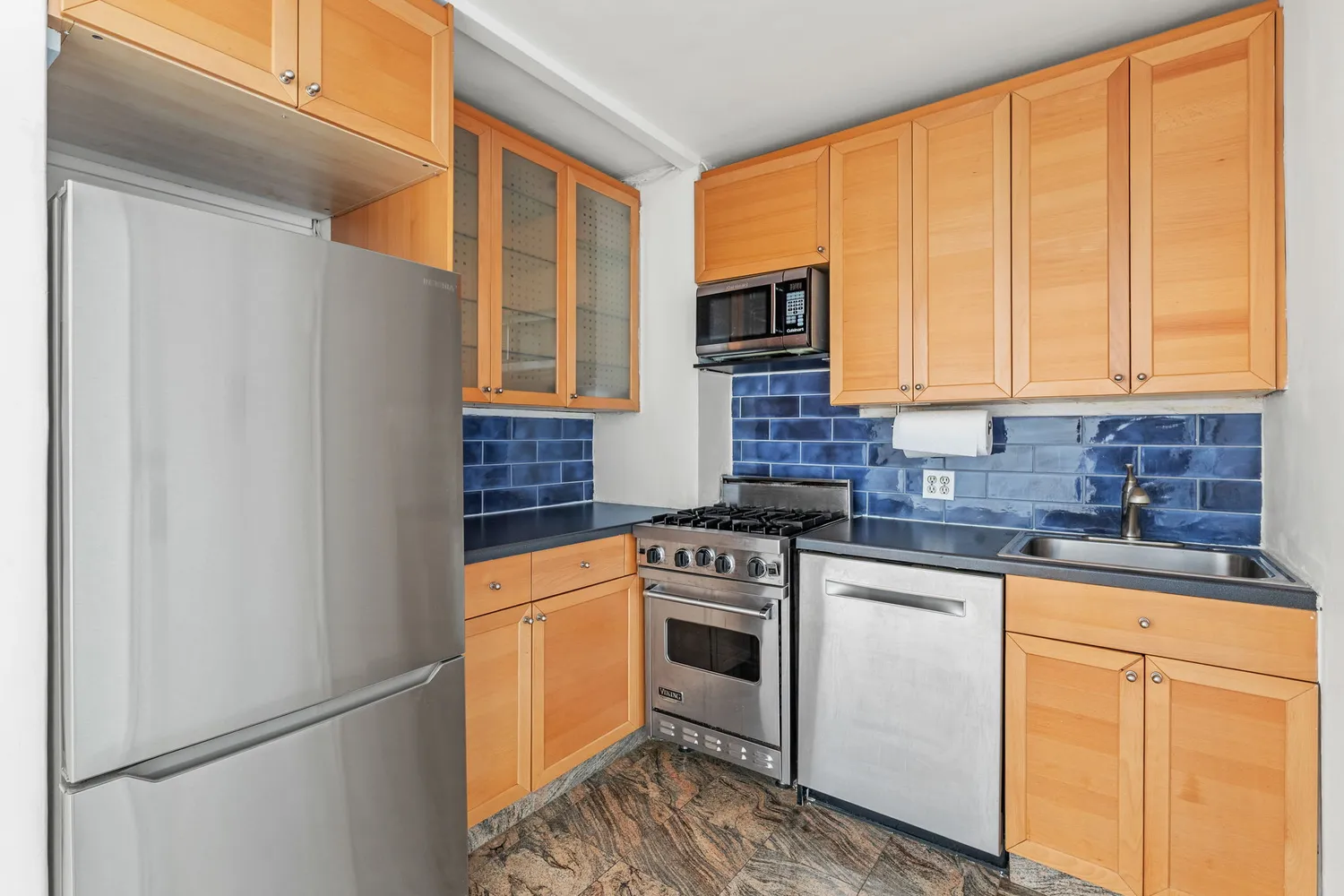 a kitchen with stainless steel appliances granite countertop a stove a sink and a refrigerator