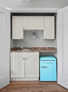 a kitchen with granite countertop white cabinets and a sink