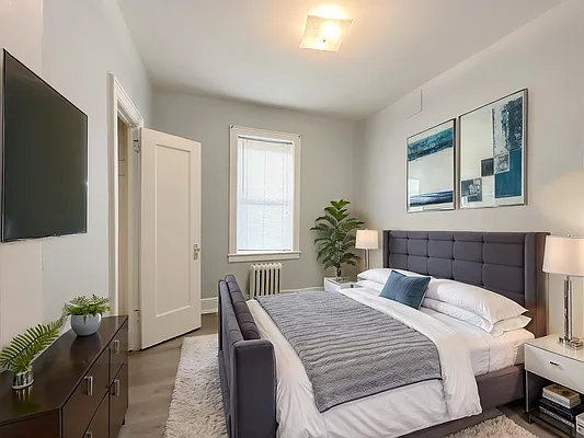 364 97th Street, Unit 2 Brooklyn, NY 11209 - Photo 4 of 8 a bedroom with a balcony a bed and a flat screen tv