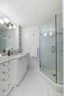 a bathroom with a double vanity sink mirror and shower