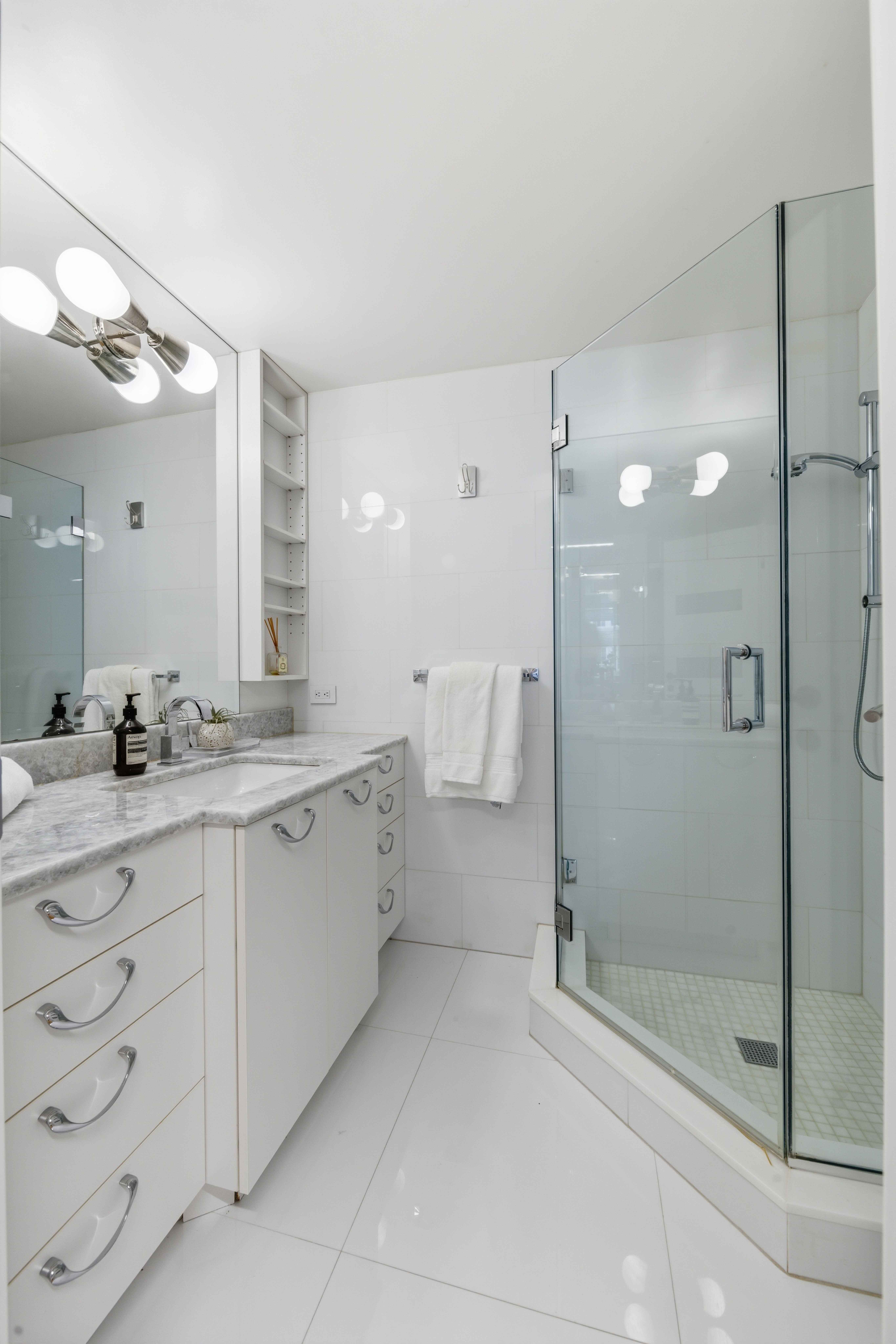 40 East 78th Street, Unit 5E Manhattan, NY 10075 - Photo 15 of 23 a bathroom with a double vanity sink mirror and shower