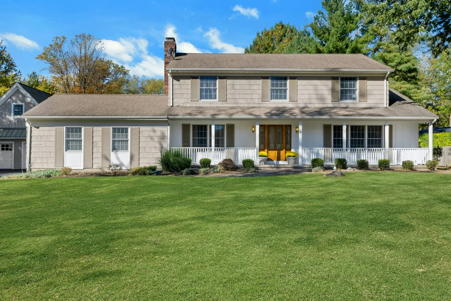 a front view of a house with garden and chairs
