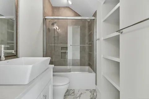 a bathroom with a granite countertop sink mirror and shower