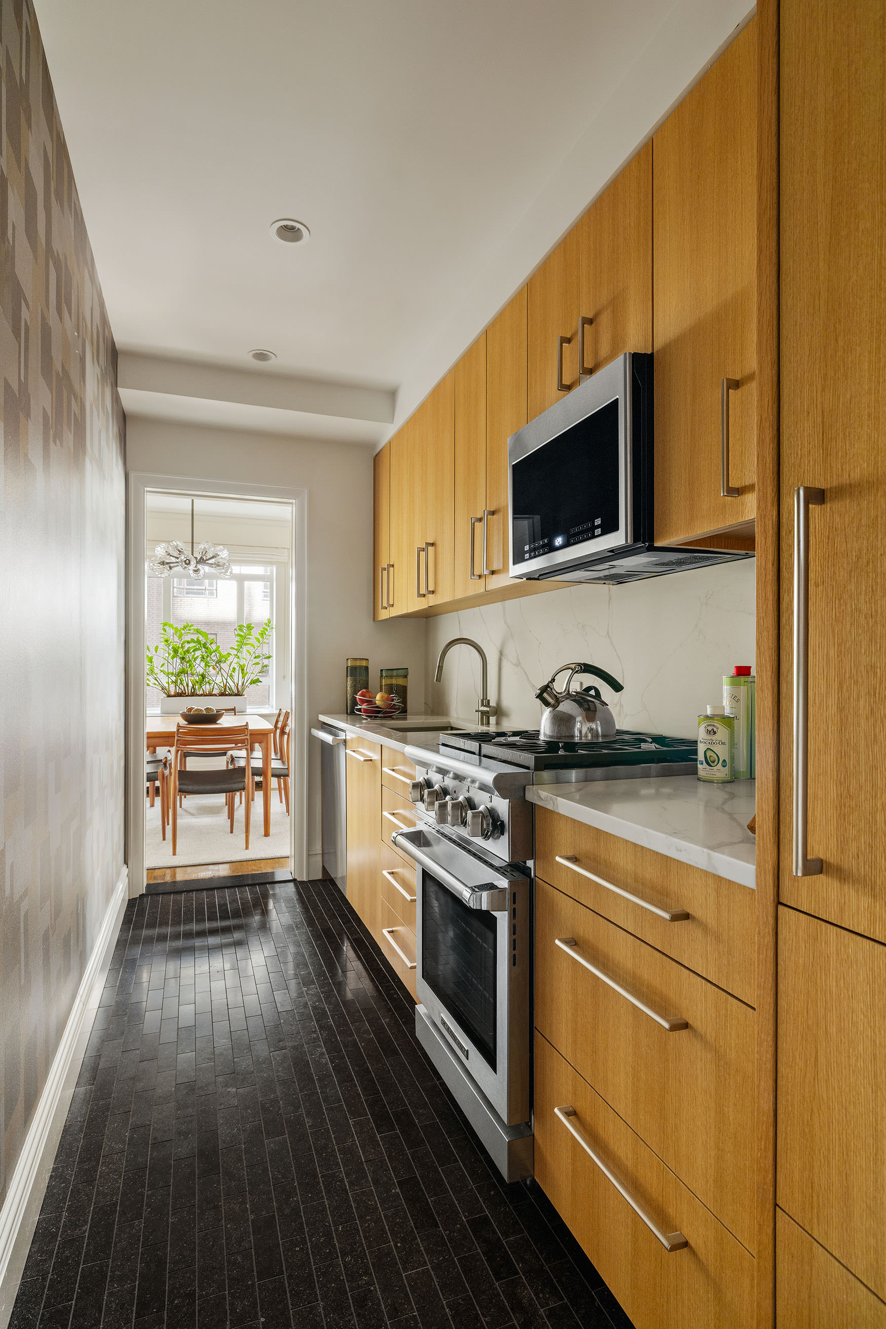 25 Central Park West, Unit 3A Manhattan, NY 10023 - Photo 7 of 11 a kitchen with stainless steel appliances a stove a sink and a microwave