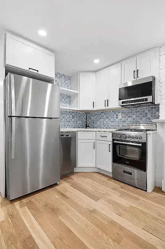 587 Van Buren Street, Unit 1 Brooklyn, NY 11221 - Photo 3 of 8 a kitchen with a refrigerator and a stove top oven