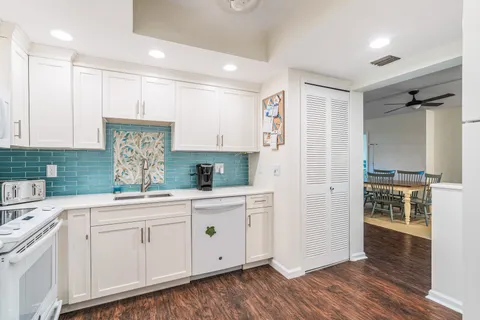 a kitchen with white cabinets and sink